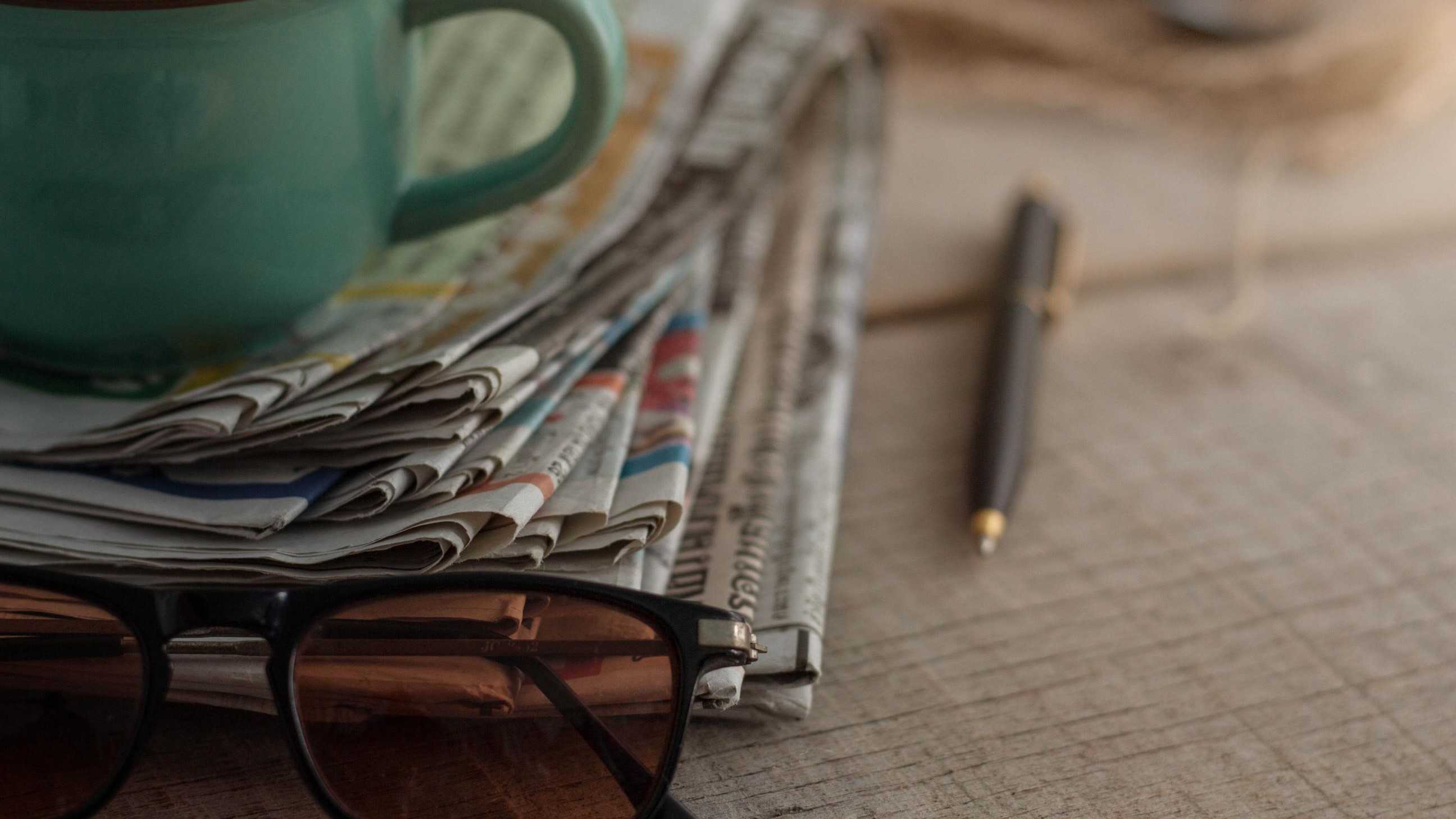 loupe déposée sur une pile de journaux